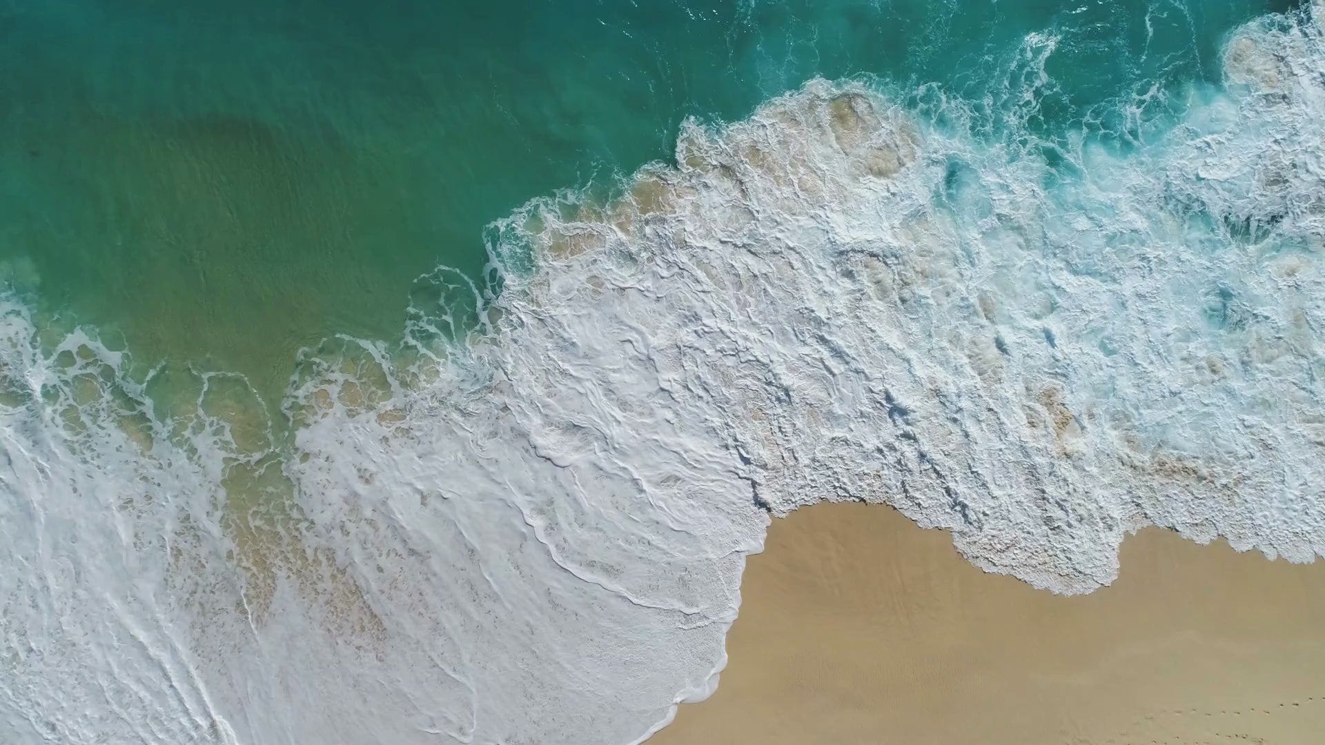 Blue water crashing on the sand